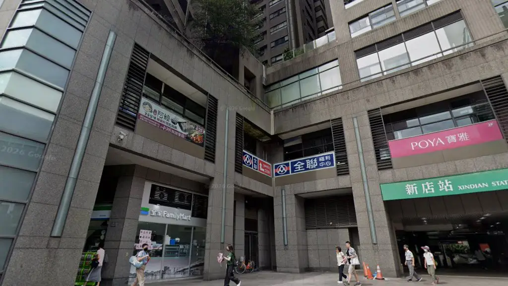 全家便利商店新店站前店的店門口,右側是捷運新店站的入口